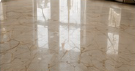 Marble floor before refinishing with uneven gloss and dull patches